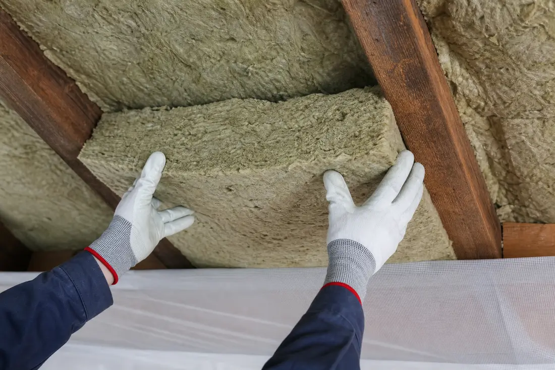 Detailansicht einer Zwischensparrendämmung mit eingelegter Mineralwolle und sichtbarem Dachsparren