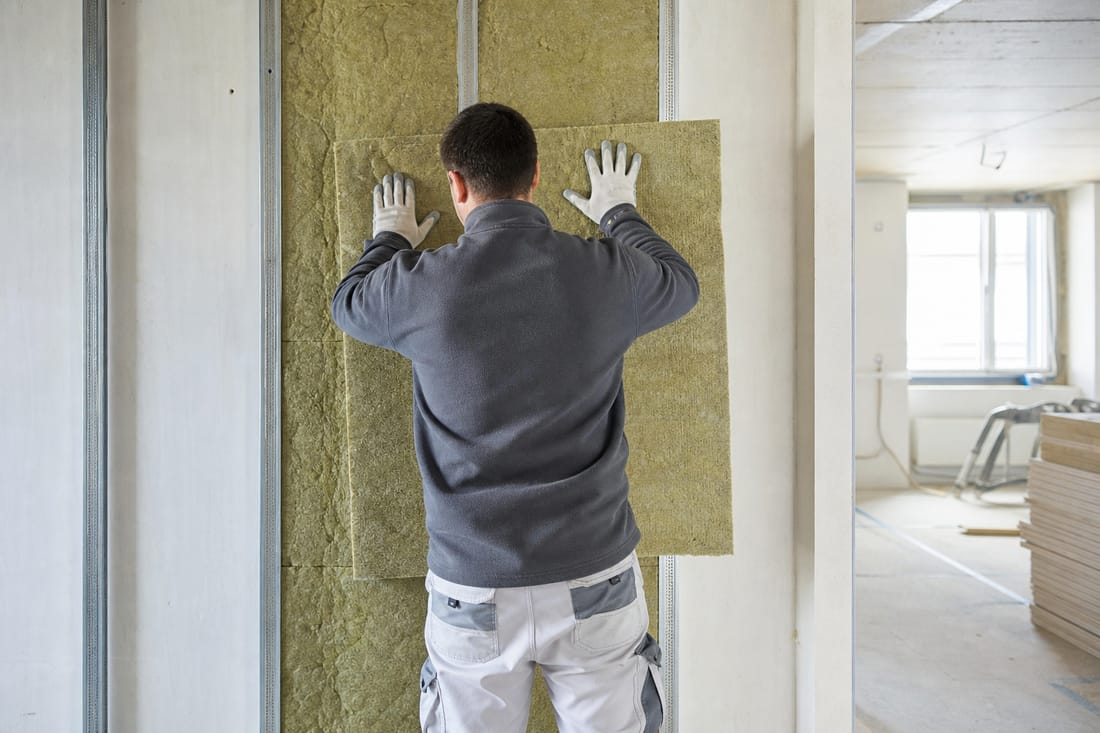 Beispiel: Handwerker von hinten beim Anbringen der Innendämmung